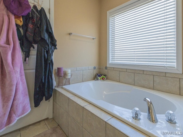 bathroom with a relaxing tiled tub and tile patterned floors