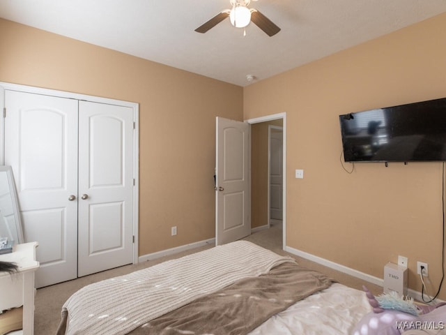 bedroom featuring light colored carpet, a closet, and ceiling fan