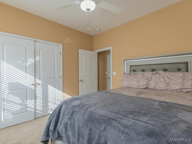 bedroom with ceiling fan, a closet, and light carpet