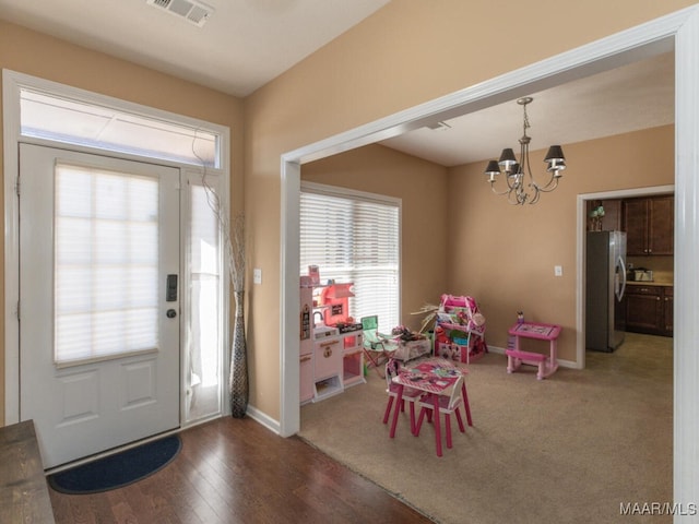 entrance foyer featuring a notable chandelier and carpet flooring