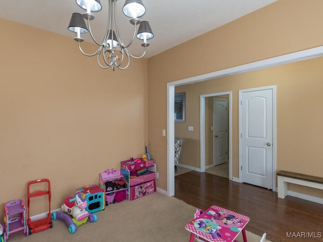 playroom with an inviting chandelier and dark hardwood / wood-style floors