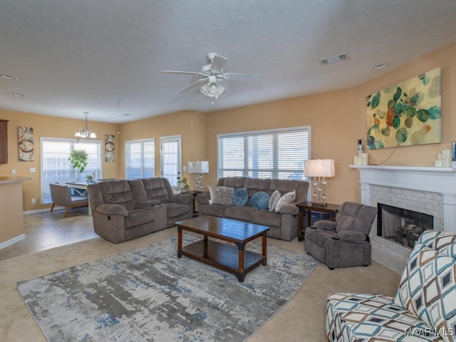 carpeted living room featuring a healthy amount of sunlight, a textured ceiling, and a brick fireplace