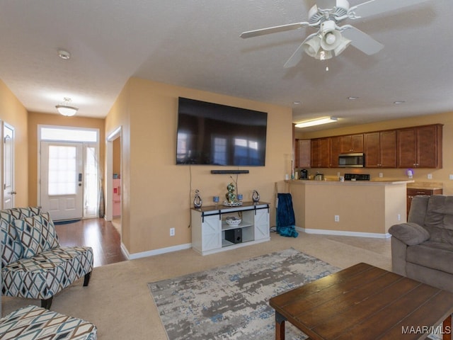 carpeted living room with ceiling fan