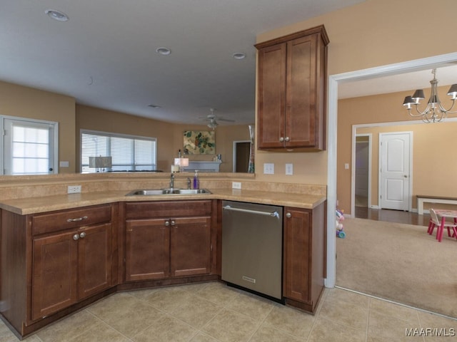 kitchen with sink, ceiling fan with notable chandelier, kitchen peninsula, and stainless steel dishwasher