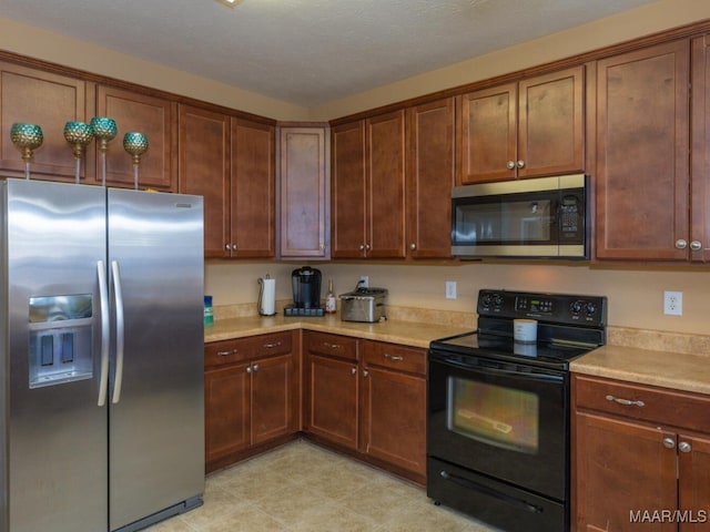 kitchen with a textured ceiling and stainless steel appliances