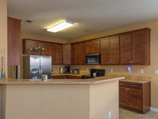 kitchen featuring kitchen peninsula, appliances with stainless steel finishes, and light tile patterned flooring