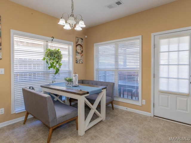 tiled dining space featuring an inviting chandelier