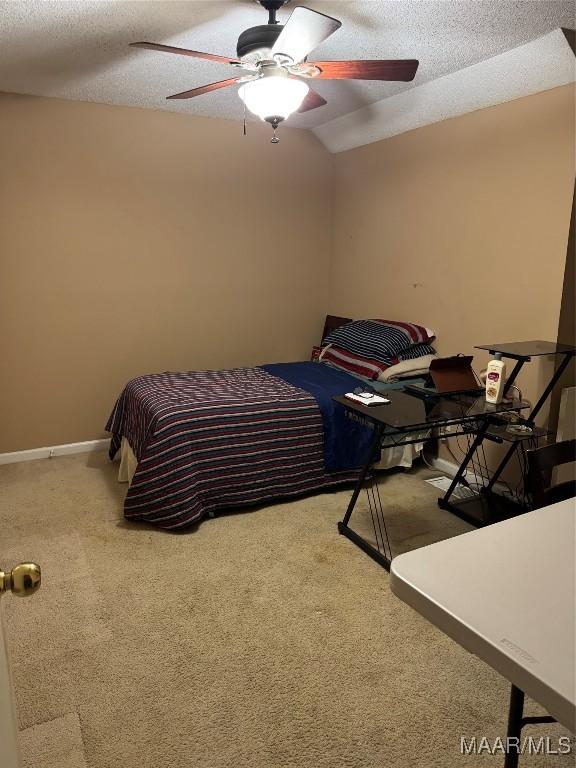 bedroom featuring carpet floors, a textured ceiling, vaulted ceiling, and ceiling fan