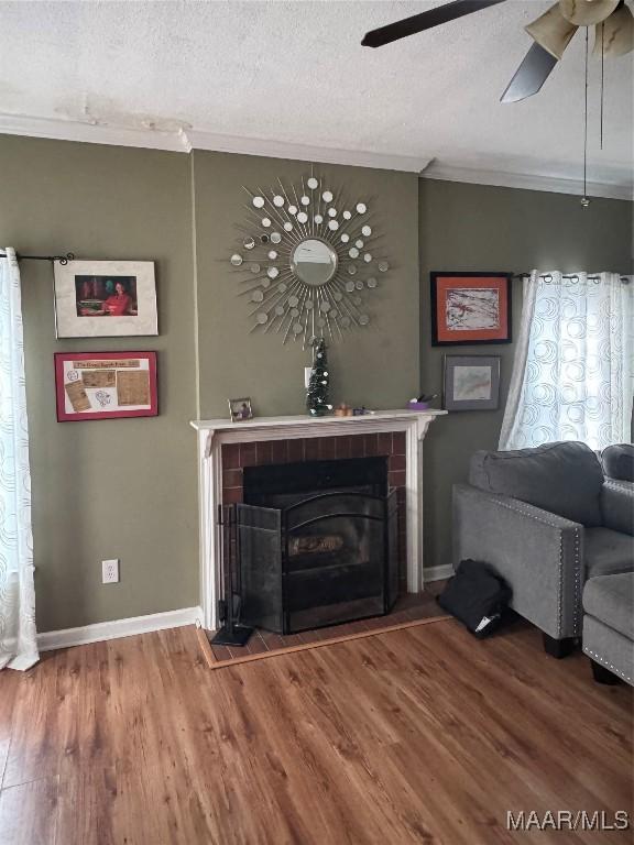 unfurnished living room featuring hardwood / wood-style floors, crown molding, a textured ceiling, and ceiling fan