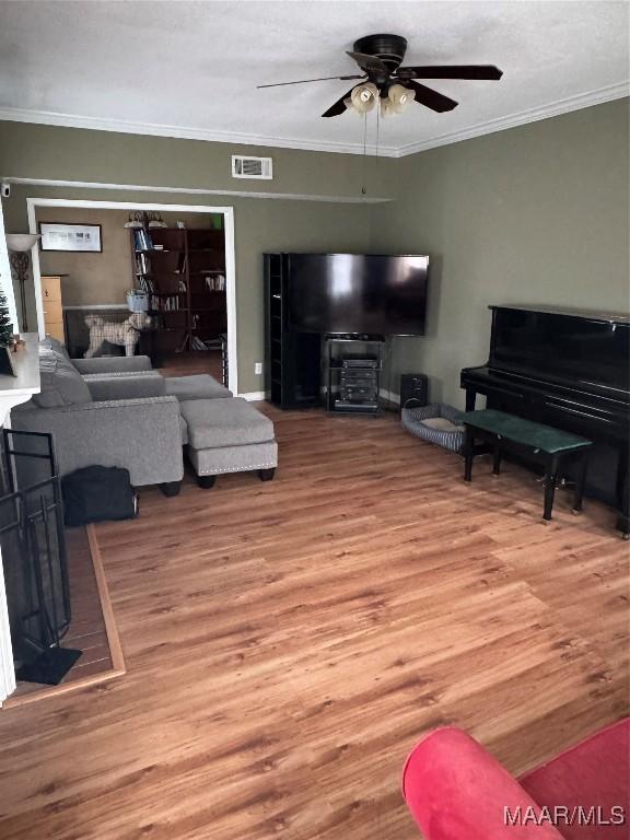 living room featuring ceiling fan, ornamental molding, and hardwood / wood-style floors