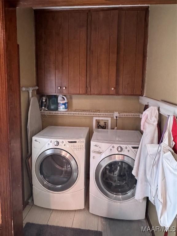 washroom with cabinets and washer and dryer