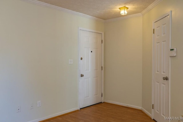 empty room with crown molding, a textured ceiling, and light hardwood / wood-style flooring