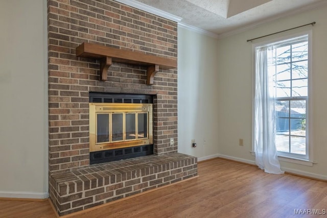 unfurnished living room featuring hardwood / wood-style flooring, crown molding, a fireplace, and a textured ceiling