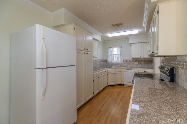 kitchen featuring white cabinetry, white appliances, light hardwood / wood-style floors, and a textured ceiling