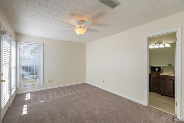 unfurnished room with ceiling fan, light colored carpet, and a textured ceiling