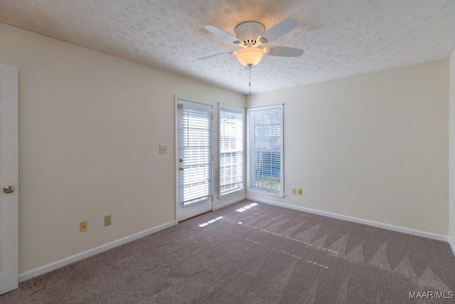 empty room with ceiling fan, carpet, and a textured ceiling