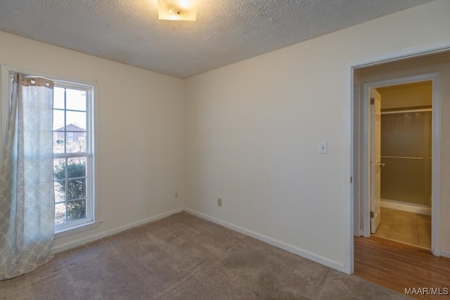 unfurnished room featuring carpet flooring and a textured ceiling