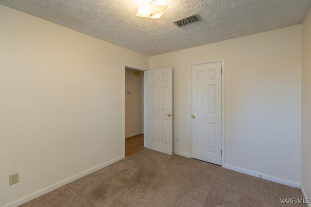 unfurnished bedroom with a closet, a textured ceiling, and carpet flooring