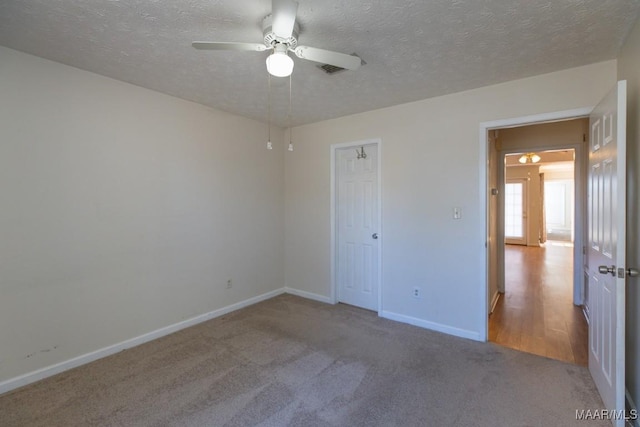 unfurnished bedroom featuring ceiling fan, a closet, carpet, and a textured ceiling