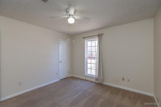 empty room featuring ceiling fan, carpet, and a textured ceiling