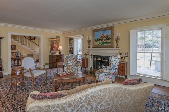 living room featuring crown molding, a high end fireplace, and wood-type flooring