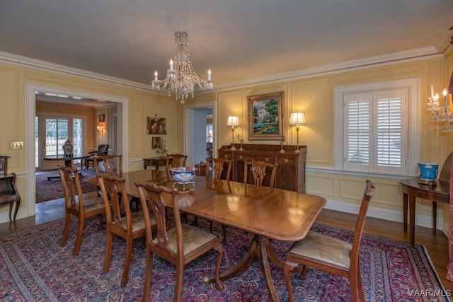 dining space featuring hardwood / wood-style floors, crown molding, a wealth of natural light, and a chandelier