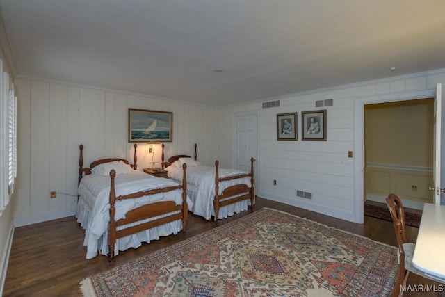 bedroom featuring ornamental molding and dark hardwood / wood-style flooring