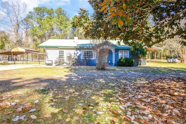 view of front of house with a carport and a front lawn