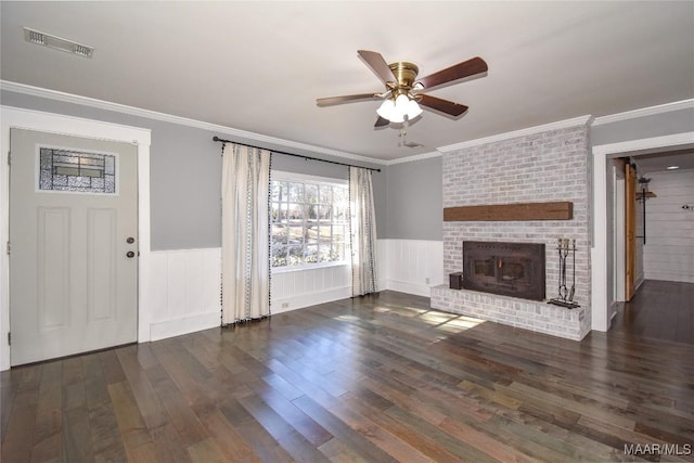 unfurnished living room with crown molding, a brick fireplace, ceiling fan, and dark hardwood / wood-style flooring