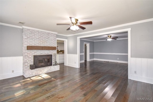 unfurnished living room featuring ceiling fan, ornamental molding, dark hardwood / wood-style flooring, and a brick fireplace