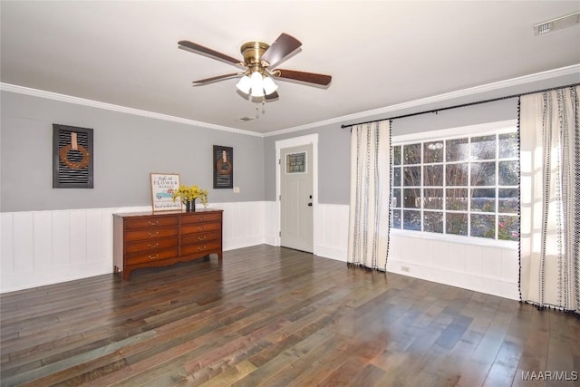 empty room featuring ornamental molding, dark wood-type flooring, and ceiling fan