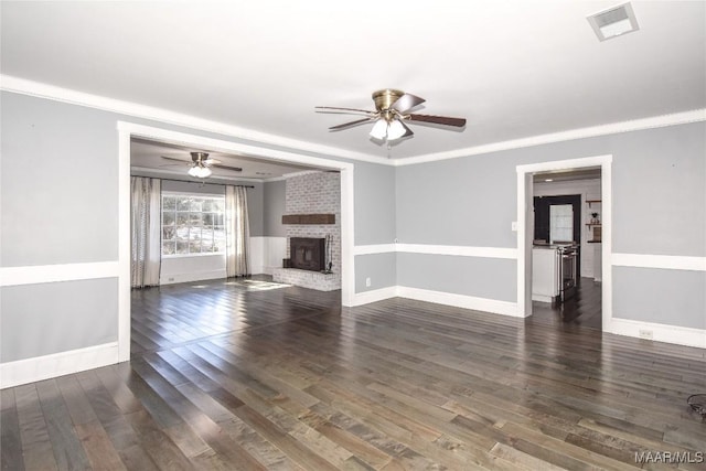 unfurnished living room with crown molding, dark hardwood / wood-style flooring, and a brick fireplace