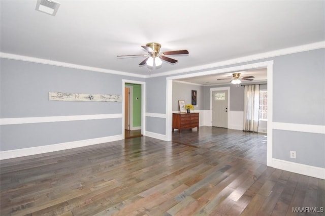 empty room featuring dark hardwood / wood-style flooring, ornamental molding, and ceiling fan