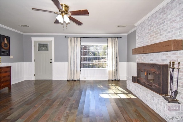 unfurnished living room with dark hardwood / wood-style flooring, crown molding, a fireplace, and ceiling fan