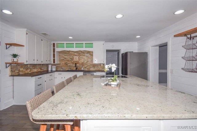 kitchen with sink, appliances with stainless steel finishes, dark stone countertops, white cabinetry, and dark hardwood / wood-style flooring