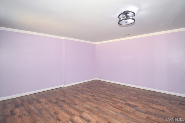 empty room with crown molding and dark wood-type flooring