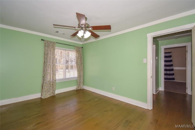 spare room with dark hardwood / wood-style flooring, ornamental molding, and ceiling fan