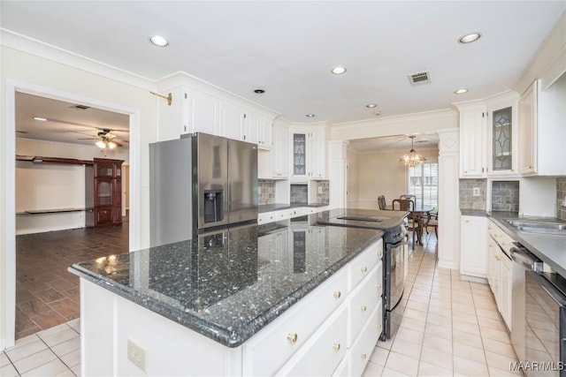 kitchen featuring hanging light fixtures, stainless steel appliances, a center island, and white cabinets