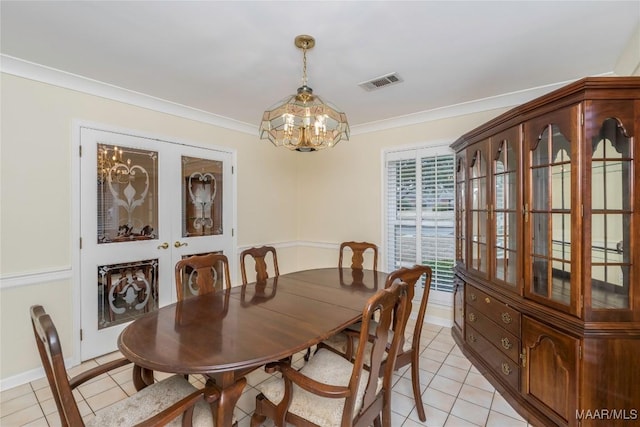 tiled dining room featuring crown molding and a chandelier