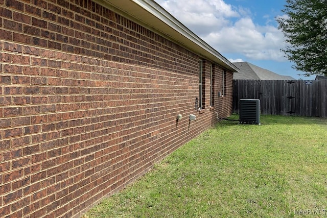 view of side of home with a lawn and central air condition unit