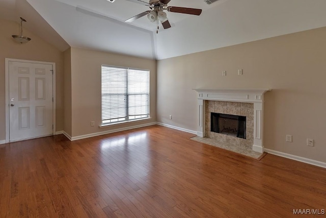 unfurnished living room with lofted ceiling, hardwood / wood-style flooring, a tile fireplace, and ceiling fan