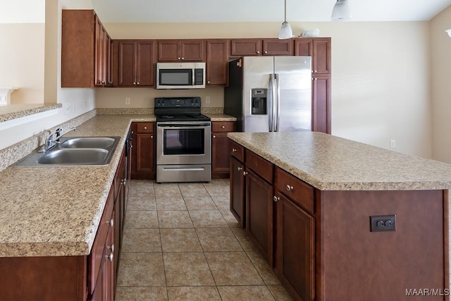 kitchen with light tile patterned flooring, sink, decorative light fixtures, a center island, and stainless steel appliances