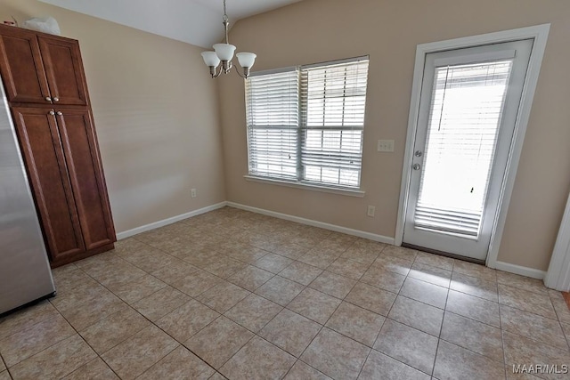 unfurnished dining area featuring light tile patterned flooring and an inviting chandelier