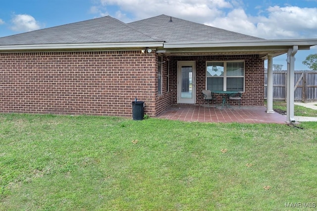 rear view of house featuring a lawn and a patio