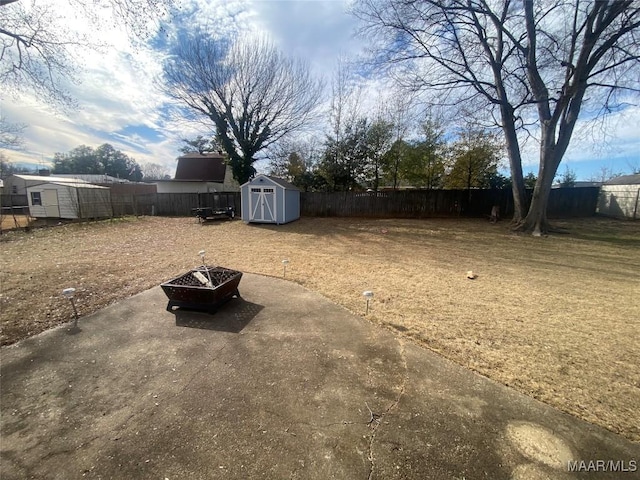 view of yard with a shed, a patio area, and an outdoor fire pit