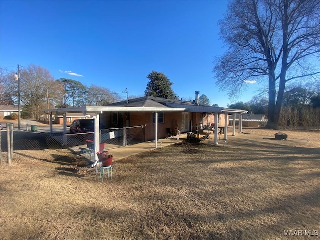 rear view of house featuring a carport and a yard