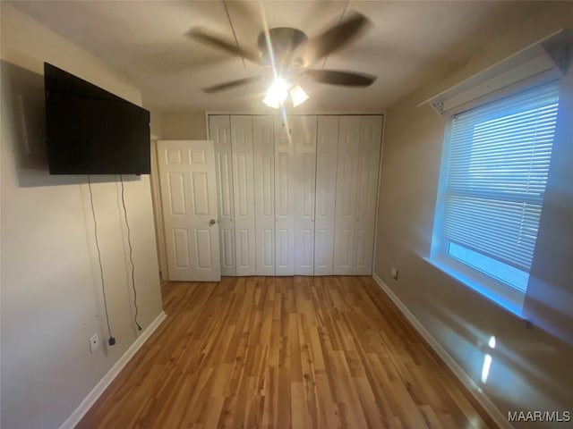 unfurnished bedroom with ceiling fan and light hardwood / wood-style flooring