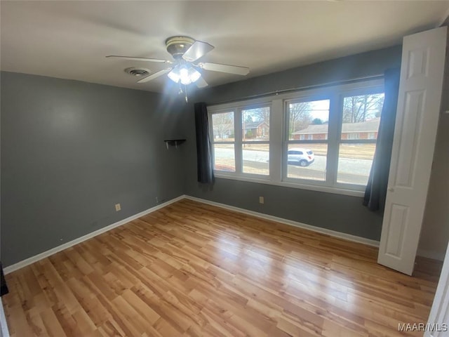 spare room with ceiling fan, a healthy amount of sunlight, and light wood-type flooring