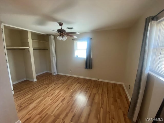 unfurnished bedroom with ceiling fan, light wood-type flooring, and a closet