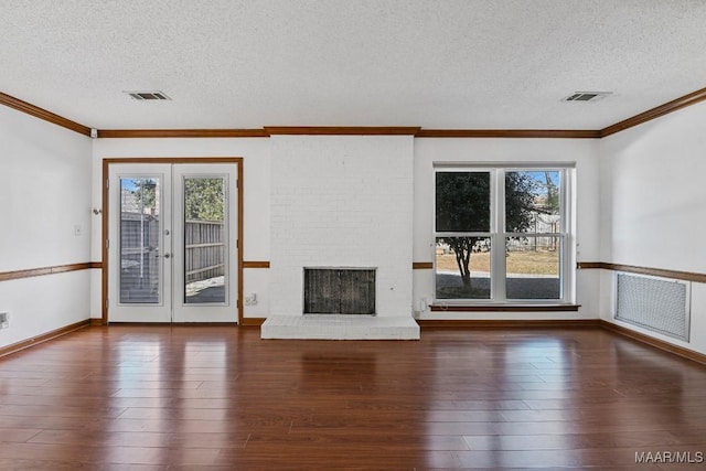 unfurnished living room with dark hardwood / wood-style flooring, a brick fireplace, french doors, and a textured ceiling